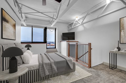 a bedroom with a bed and a tv in a loft at 100 South Apartments, Buffalo